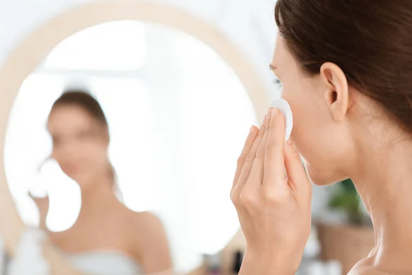 Sluiten van onherkenbare dame schoonmaken van haar gezicht met lotion — Stockfoto