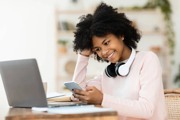 African Girl SMS-y w telefonie do pracy domowej na laptopie w pomieszczeniach — Zdjęcie stockowe