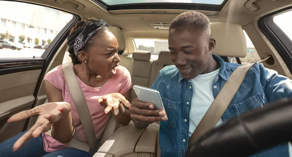 Furious girl yelling at her boyfriend using smartphone while driving