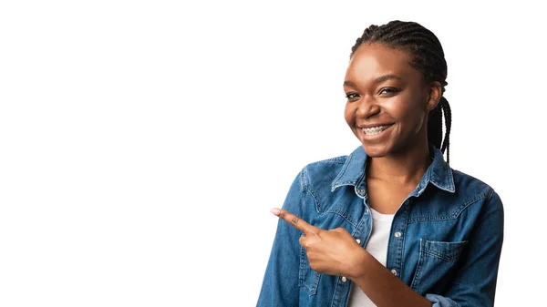 Africaine fille avec des parenthèses pointant doigt à côté sur fond blanc — Photo