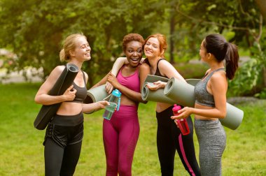 Yoga dersinden önce parkta çeşitli genç bayanlar konuşup gülüyor.
