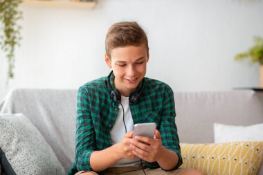 Akıllı telefon tutan, sosyal medyayı kontrol eden mutlu adam.