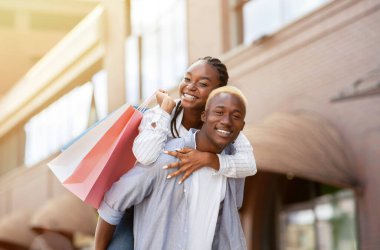 Boş zaman, boş zaman ve satın alma. Kağıt torbalı, gülümseyen çift mağazanın yanında eğleniyor.