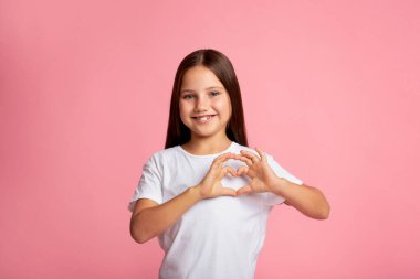 Sevgi ve şefkat duygularının ifadesi. Gülümseyen küçük kız elleriyle kalp işareti yapıyor.