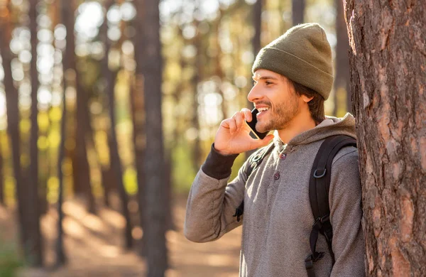 Szczęśliwy młody człowiek Backpacker rozmawia przez telefon podczas wędrówki — Zdjęcie stockowe