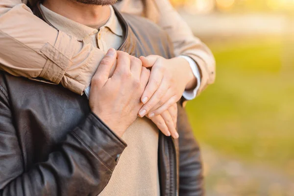 Female hands hugging man from behind, park background — Stock Photo, Image