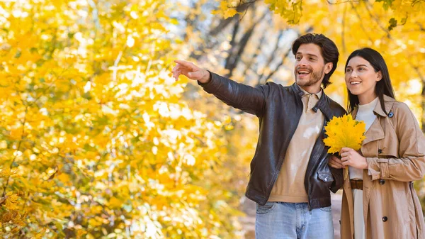 Hombre enamorado mostrando a la mujer algo, apuntando al espacio de copia —  Fotos de Stock