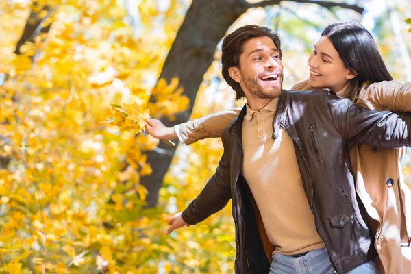 Uomo e donna innamorati che imitano aeroplano nel parco dorato — Foto Stock