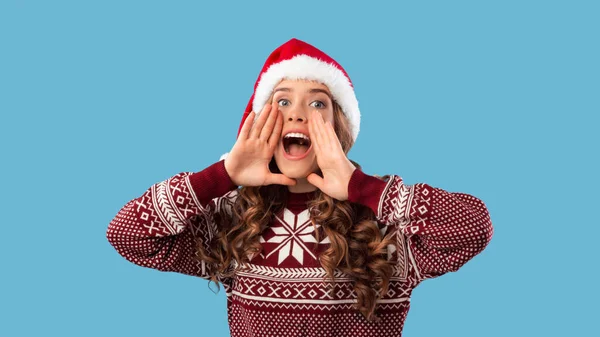 Descuento de Navidad. Hermosa mujer milenaria en Santa sombrero gritando sobre fondo azul — Foto de Stock