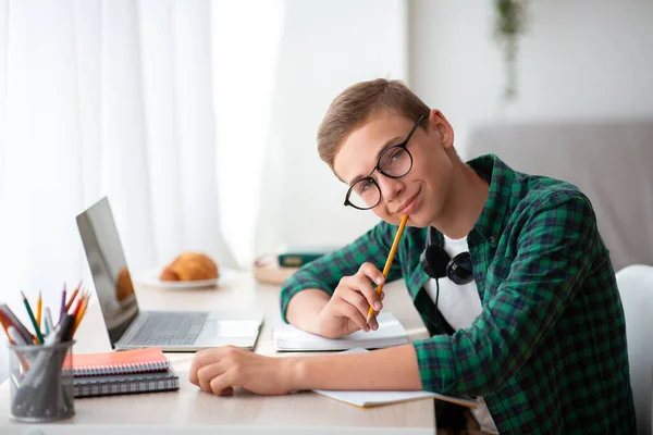 Leende nörd kille njuter av sina studier hemma — Stockfoto