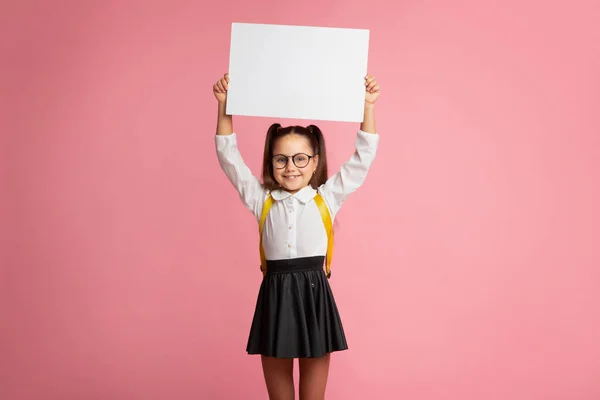 Preparazione per la scuola. Ragazzina sorridente con zaino in occhiali, segno di tenuta con spazio vuoto — Foto Stock