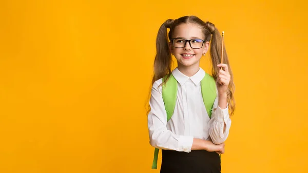 Schoolgirl Pointing Pencil Up Having Idea On Yellow Background, Panorama — 스톡 사진