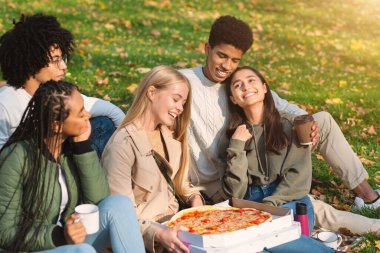 Gençler parkta piknik yapıyor.