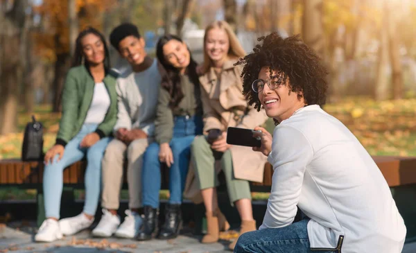 Africano cara tirando foto de seus amigos internacionais — Fotografia de Stock