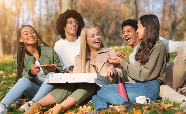 Vreugdevolle tienervrienden die lachen en pizza eten — Stockfoto
