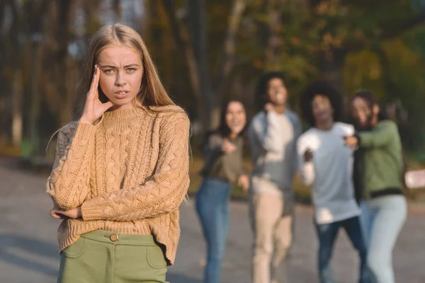 Rozčílený blondýny dívka přes smích skupina teenagerů — Stock fotografie