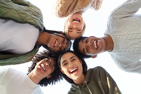 Glimlachende multiraciale vrienden die een cirkel van hoofden vormen — Stockfoto