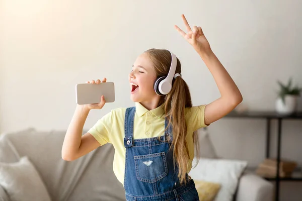 Ragazza adolescente che canta usando smartphone come microfono — Foto Stock