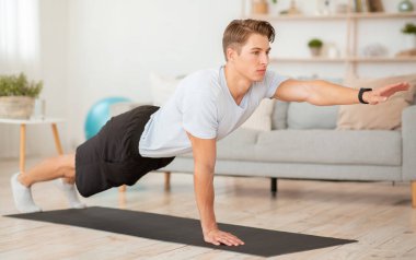 Evde vücut bakımı ve fitness. Fitness takip cihazı eğitimi almış genç bir adam.