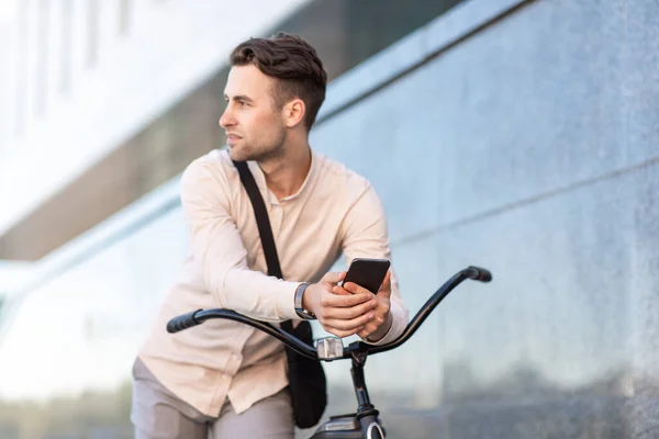 Redes sociais e online ao ar livre. Empresário em bicicleta escrevendo sms na cidade — Fotografia de Stock
