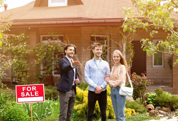 Junges Ehepaar trifft Immobilienmanager, um sich Haus zum Verkauf anzusehen — Stockfoto