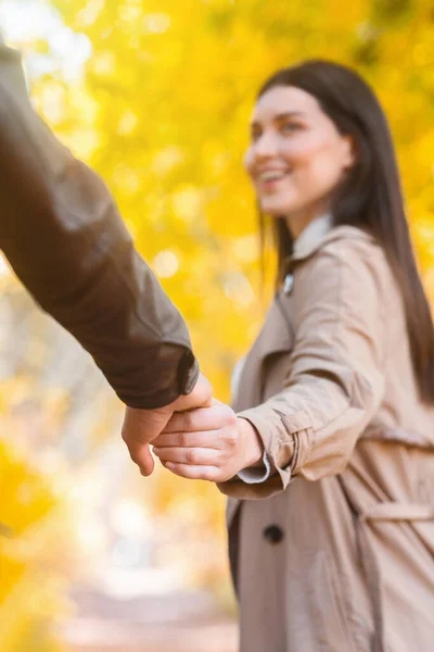 Menina emocional guiando seu namorado pela floresta de outono, close-up — Fotografia de Stock