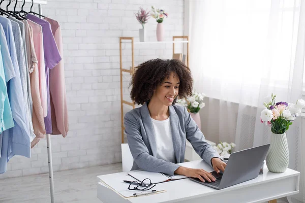 Trabajar en casa durante la cuarentena covid-19. Mujer afroamericana feliz escribiendo en el ordenador portátil — Foto de Stock