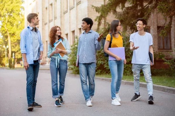 多元文化一年级学生小组在大学大楼外步行 — 图库照片