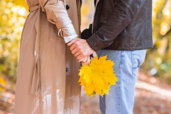 一个女人拿着一束金黄的叶子和一个男人 — 图库照片