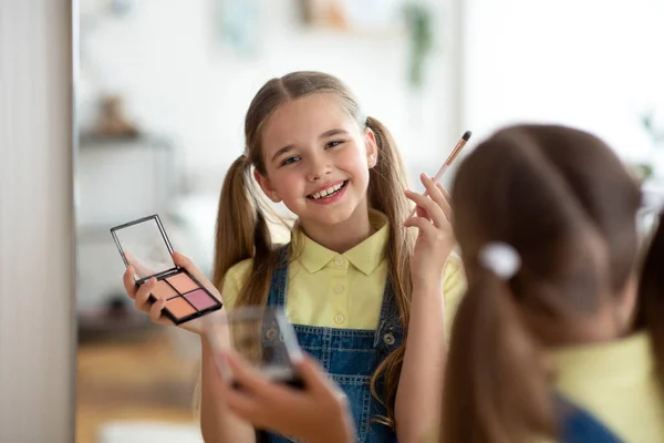 Jeune fille portant le maquillage quotidien regardant le miroir — Photo