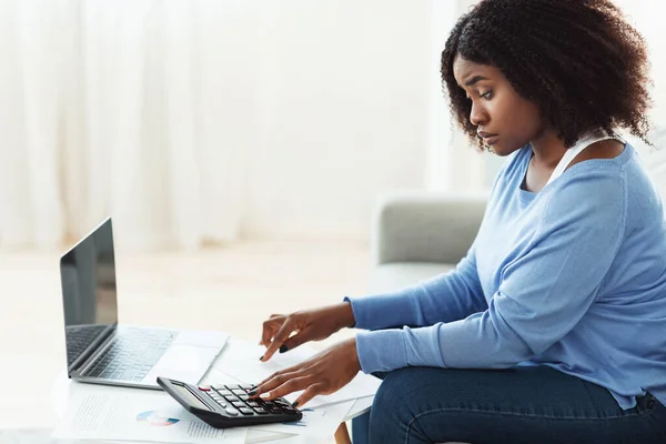Schwarze Frau benutzt Taschenrechner und PC zu Hause — Stockfoto