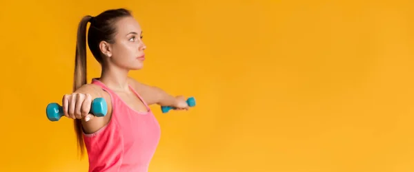 Jovem desportiva mulher formação com halteres sobre fundo amarelo — Fotografia de Stock