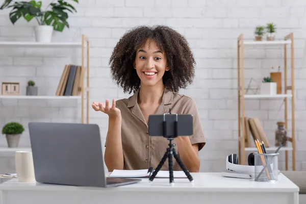Moderno hobby y concepto de blog. Mujer feliz mirando webcam sentado en la mesa en el interior — Foto de Stock