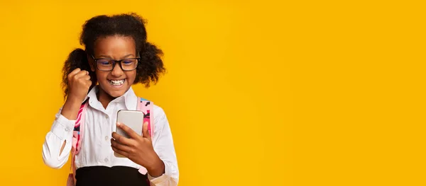 具有手机游戏、黄色背景、全景的非洲女学生 — 图库照片