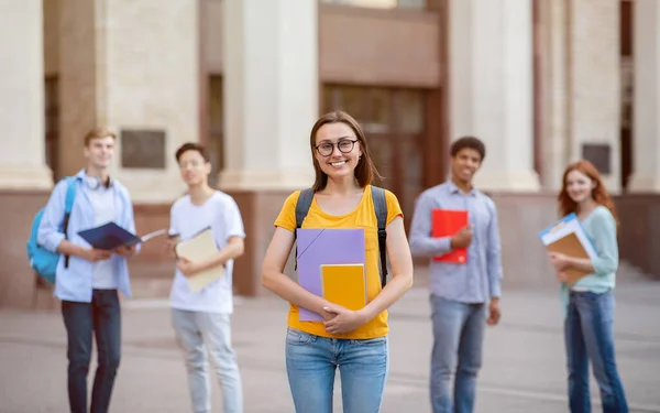 Studente ragazza in piedi vicino edificio universitario all'aperto, in posa con lo zaino — Foto Stock