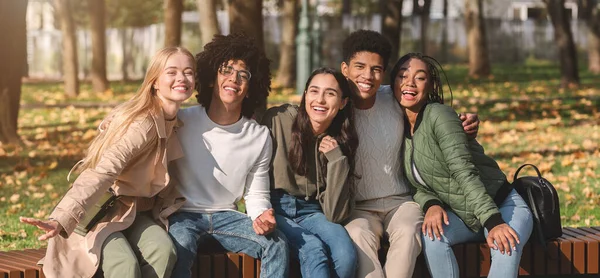 Panoramafoto von fröhlichen multirassischen Teenagern, die sich im Park ausruhen — Stockfoto