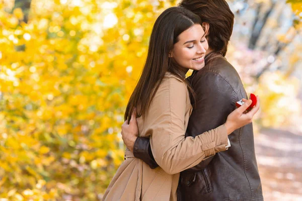 Vrouw op zoek naar aanzoek ring terwijl knuffelen haar vriend — Stockfoto