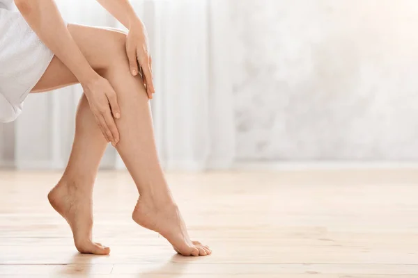 Primer plano de las piernas femeninas, mujer disfrutando de su piel sedosa — Foto de Stock