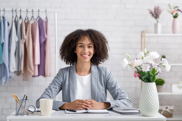 Sorrindo jovem estilista ou designer de moda. Mulher com bloco de notas no local de trabalho — Fotografia de Stock