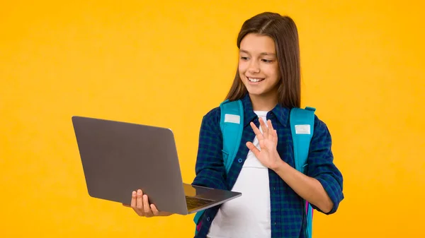 Mutlu kız video çağrısı ve el sallama için dizüstü bilgisayar kullanıyor — Stok fotoğraf
