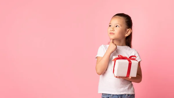 Glückliches Mädchen mit Geschenkbox im rosa Studio — Stockfoto
