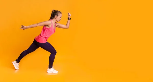 Motivado jovem mulher em Sportswear correndo sobre fundo amarelo — Fotografia de Stock