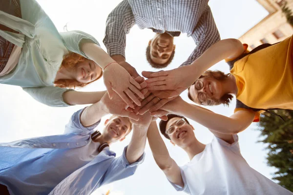 Studenti che tengono le mani in piedi in cerchio all'aperto, Colpo in basso — Foto Stock