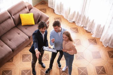 Ev planlı bir emlakçı genç evli çifti satılık olarak gösteriyor.