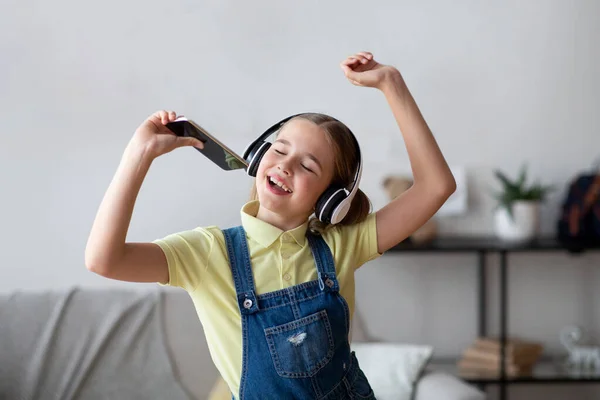 Дівчина-підліток співає з використанням мобільного телефону як мікрофон — стокове фото