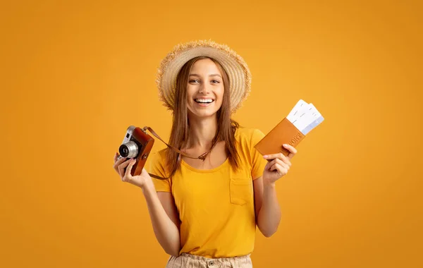 Usmívající se mladá žena v letním klobouku drží fotoaparát a pas — Stock fotografie