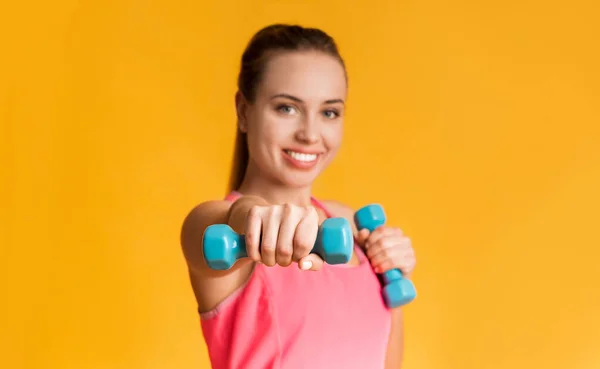 Sportovní dívka dumbbell box cvičení přes žluté studio pozadí — Stock fotografie