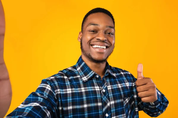 Afro-americano cara gestando polegares-up fazendo selfie sobre fundo amarelo — Fotografia de Stock