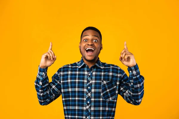 Emocionado chico afroamericano posando señalando los dedos hacia arriba, fondo amarillo — Foto de Stock