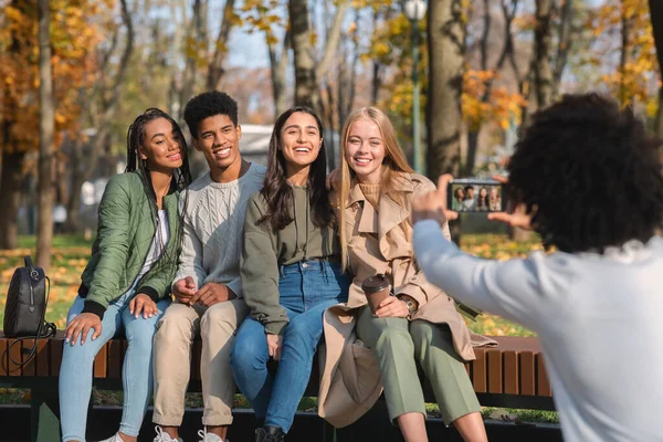 Черный подросток фотографирует своих международных друзей — стоковое фото